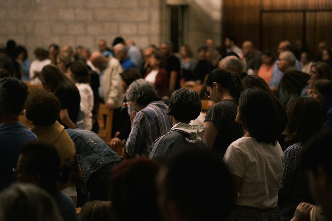 People gathered together in a hall, listening.