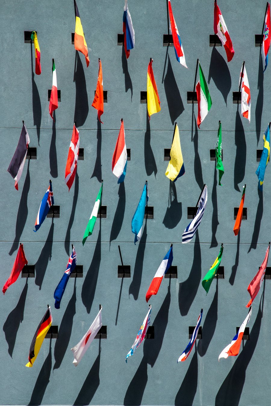 National flags mounted in rows on a wall.